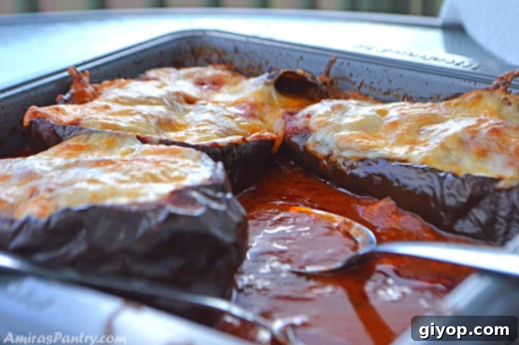 Honoring Dad with a Healthier Egyptian Moussaka 3 eggplant boats in a baking dish with tomato sauce.