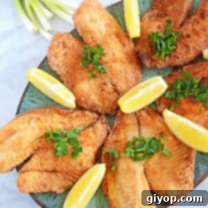 An overhead image of perfectly fried tilapia fillets arranged beautifully on a platter.