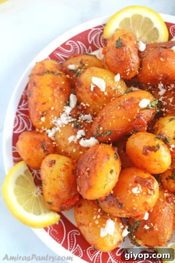 Fiery Lebanese Potatoes 2 A white plate with a red rim of spicy potato salad with lemon rinds.