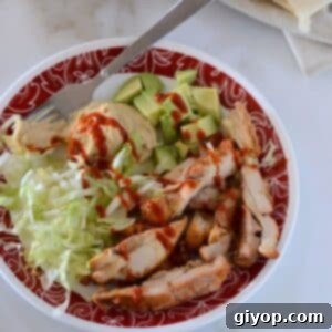 Tender & Flavorful Boneless Baked Chicken Thighs 2 A top view of a plate with baked chicken thighs and some condiments.