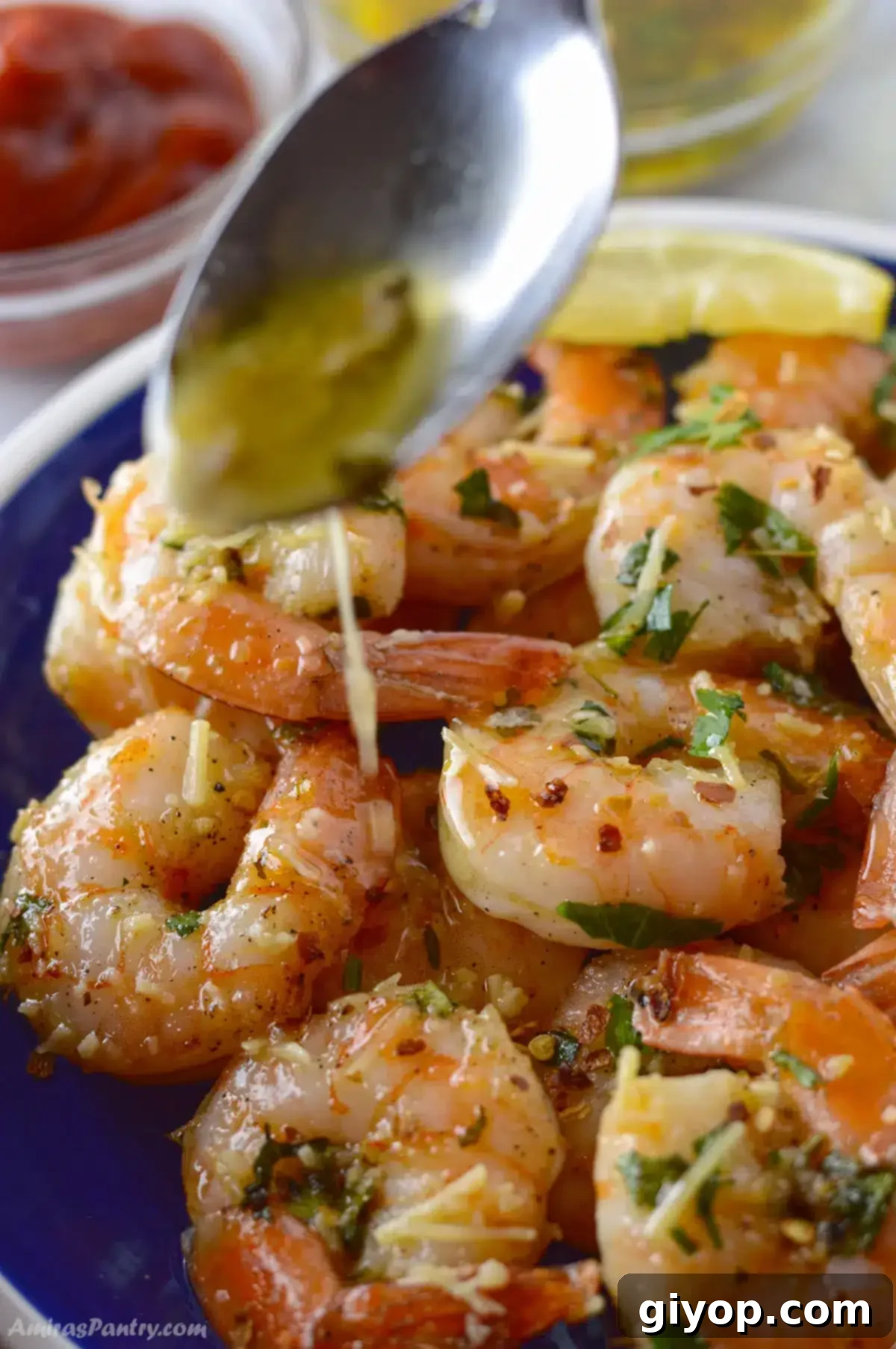 Golden Garlic Shrimp Bake 4 A spoon pouring some scampi sauce over shrimp.