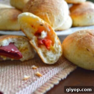 Golden Stuffed Delights 2 Close-up of freshly baked Stuffed Egyptian Rolls on a table, with one cut in half to reveal the savory filling.