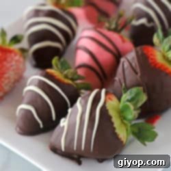 A close up of strawberries dipped in chocolate on a plate