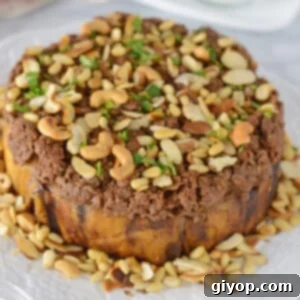 Maqluba: Savory Upside-Down Layers of Beef, Eggplant, and Rice 2 A top image of maqluba platter garnished with pine nuts.