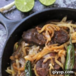 A vibrant dish of beef liver and onions served with fresh garnishes