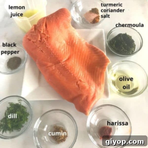 Close-up of the ingredients for baked Moroccan salmon, showcasing fresh herbs, spices, lemon, and salmon fillets.