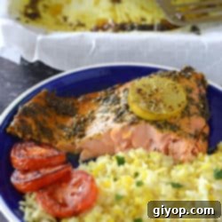 A vibrant piece of baked Moroccan salmon with yellow rice on a blue plate, ready to be enjoyed.