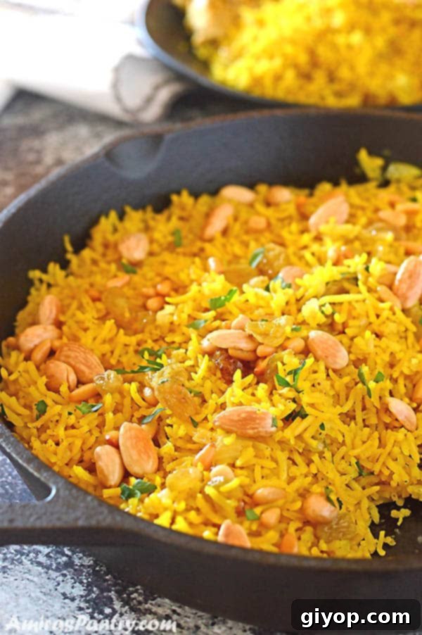 Effortless Freezer Meals 7 Yellow rice in a cast iron pan garnished with nuts and parsley.