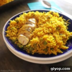 Yellow rice and chicken place on a dark blur plate with white rim