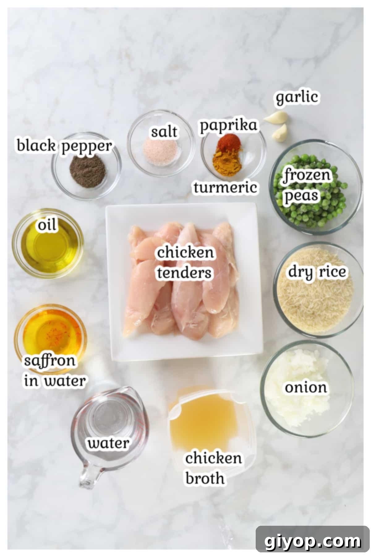 Various fresh ingredients for the chicken and rice recipe laid out neatly on a kitchen countertop, including chicken, rice, spices, onion, garlic, and peas.
