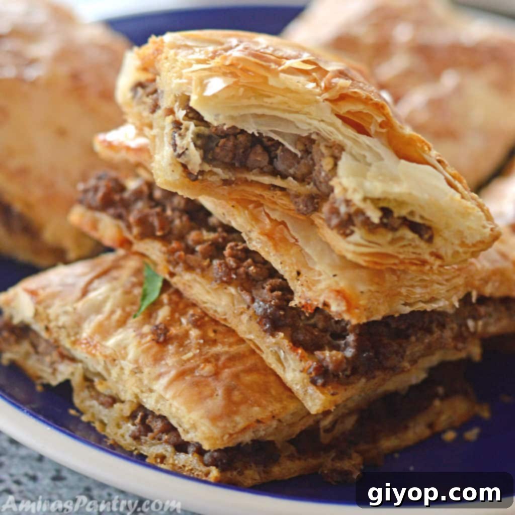 Phyllo squares cut and stacked on top of eachother on a blue plate with a white rim.
