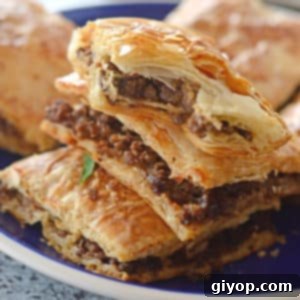 A close up of a phyllo pie on a plate, stuffed with ground beef