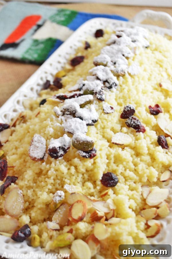 A close-up of a bowl of sweet couscous garnished with almonds and pistachios.