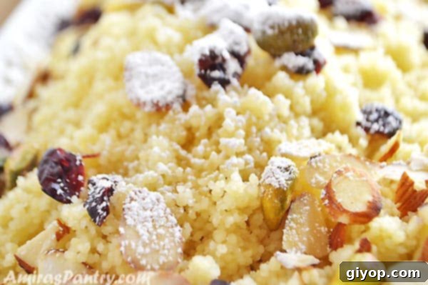 A top-down view of sweet couscous in a white bowl, adorned with various nuts and dried fruits.