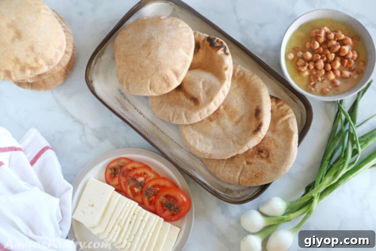 An Egyptian breakfast table featuring whole wheat pita bread, ful medammes, and white cheese.