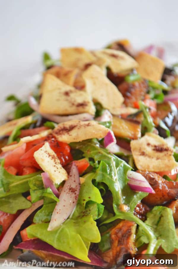 Effortless Eggplant Salad 3 Eggplant salad on a white dish with pita chips, showcasing the beautiful presentation.