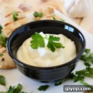 Authentic Lebanese Toum Garlic Sauce Recipe 5 A black bowl with toum garnished with parsley.