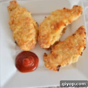 Oved fried chicken tenders on a white plate with ketchup.