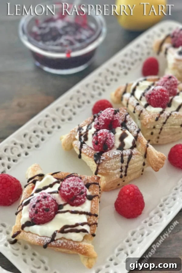 A close up of a lemon raspberry tart on a plate with fresh berries, showcasing its delicate appeal.