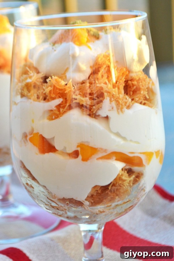 A close up of a cup filled with layers of mango and cream, showcasing a delightful parfait.