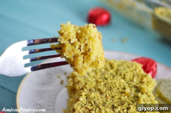 An overhead view of a freshly baked pistachio semolina cake, showcasing its golden crust and the generous topping of chopped pistachios.