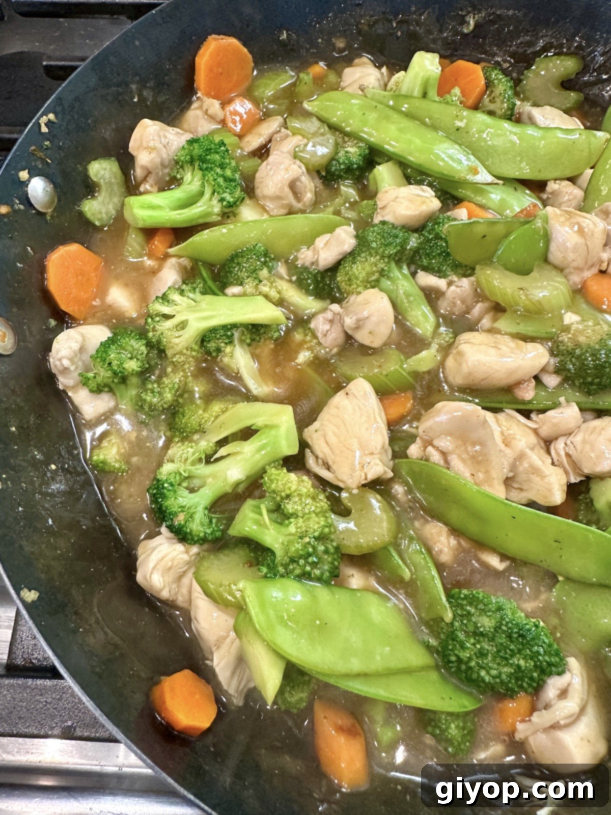 Veggies for cashew chicken stir fry with chicken in a pan.