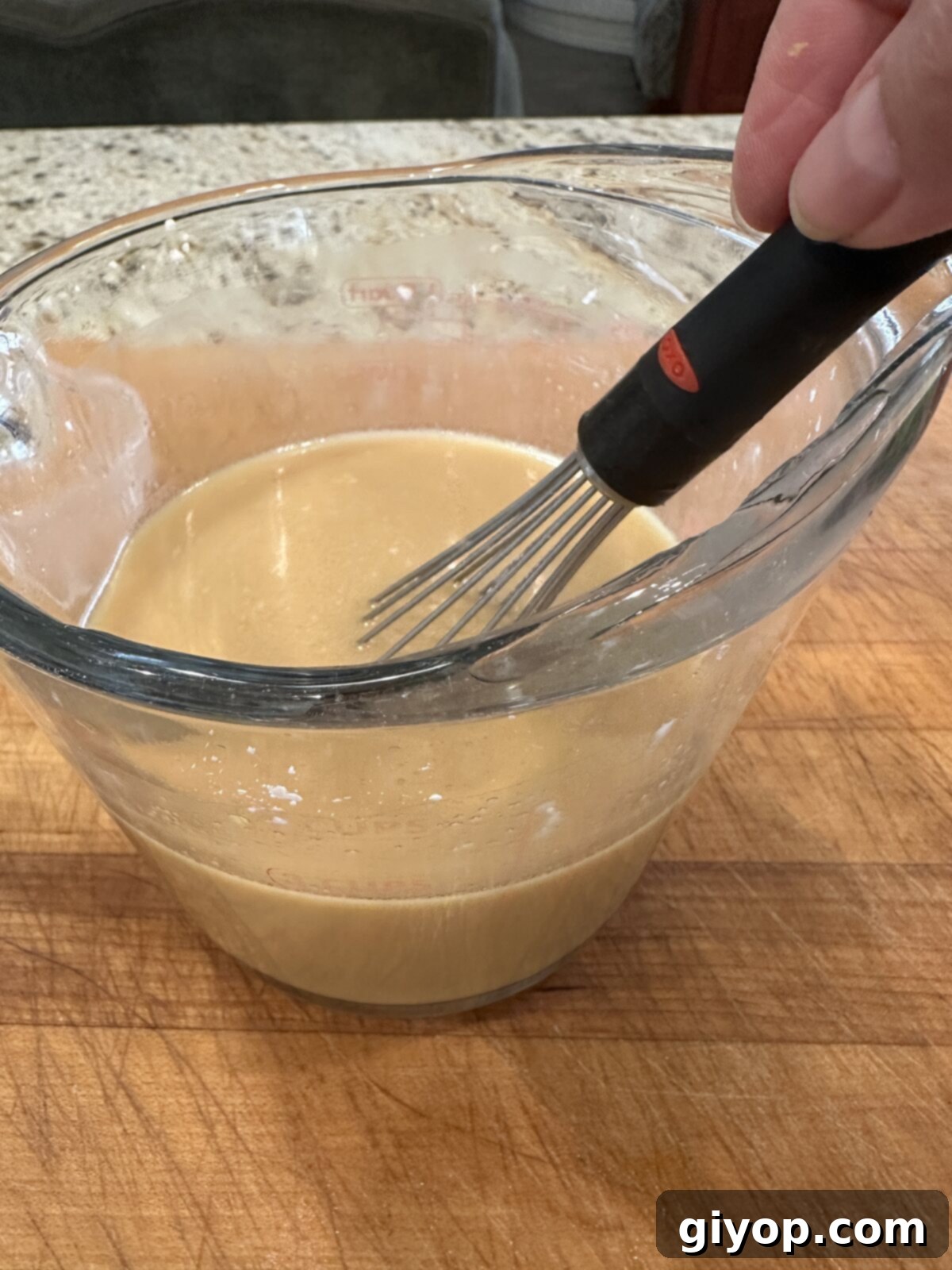 Sauce for cashew chicken stir fry in a measuring cup.