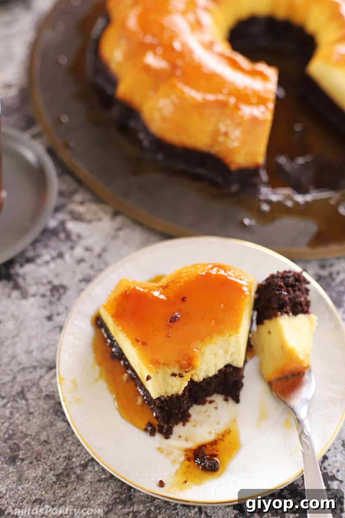 Impossible Chocolate Flan 8 a chocolate flan cake piece placed on a white dessert plate with the whole cake on the back
