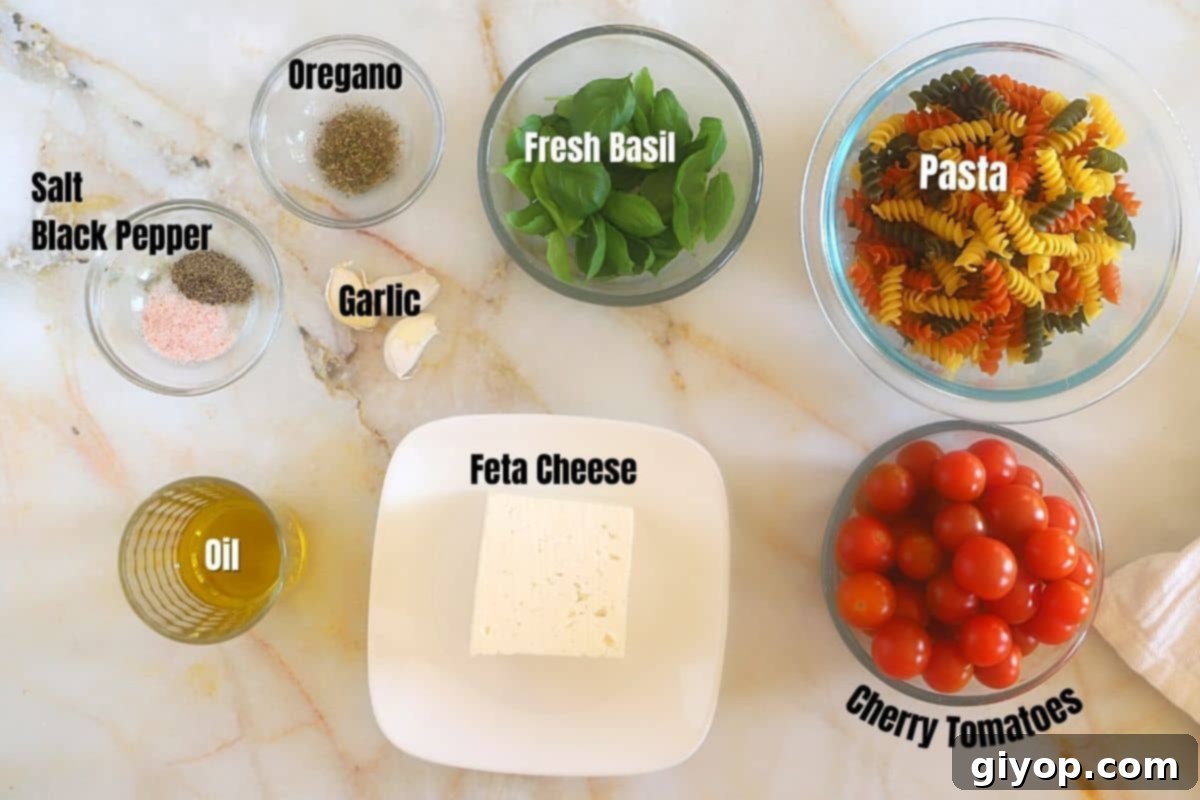 Creamy Tomato Feta Pasta 3 Baked feta pasta ingredients on a marble surface.