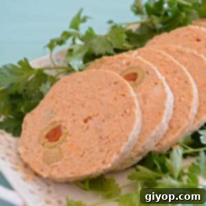 Sliced chicken roll with olives on a white plate.