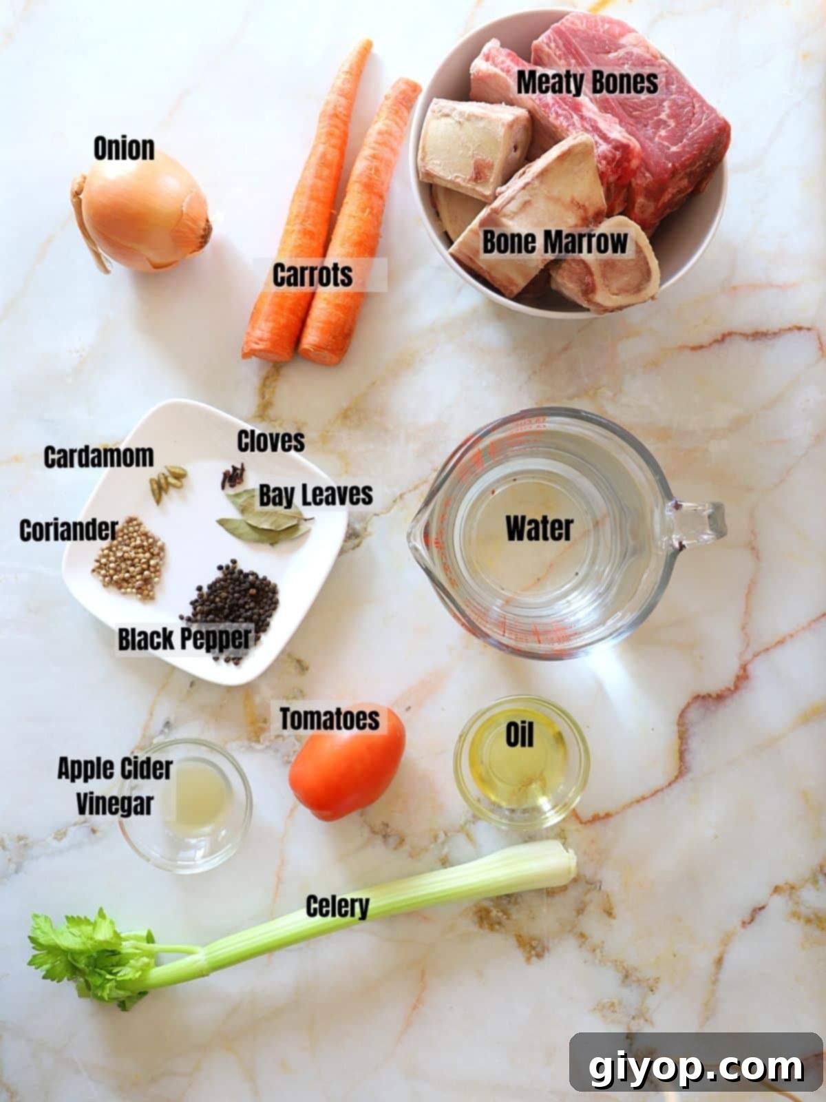 Ingredients to make bone broth on a white marble table.