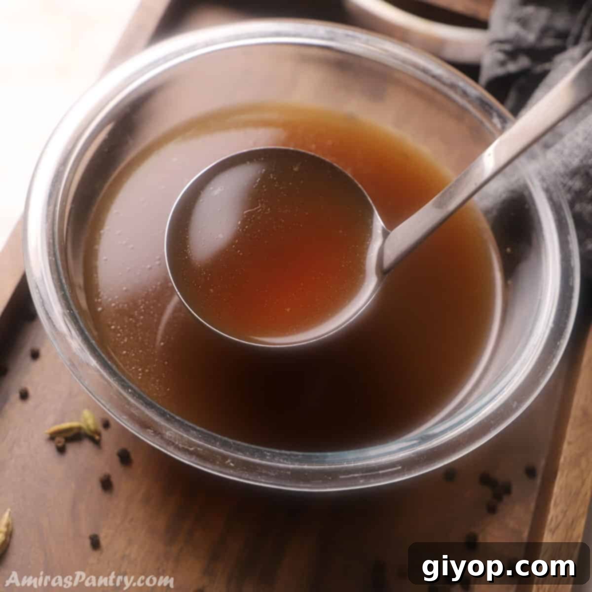 A ladle scooping some bone broth from a big bowl.