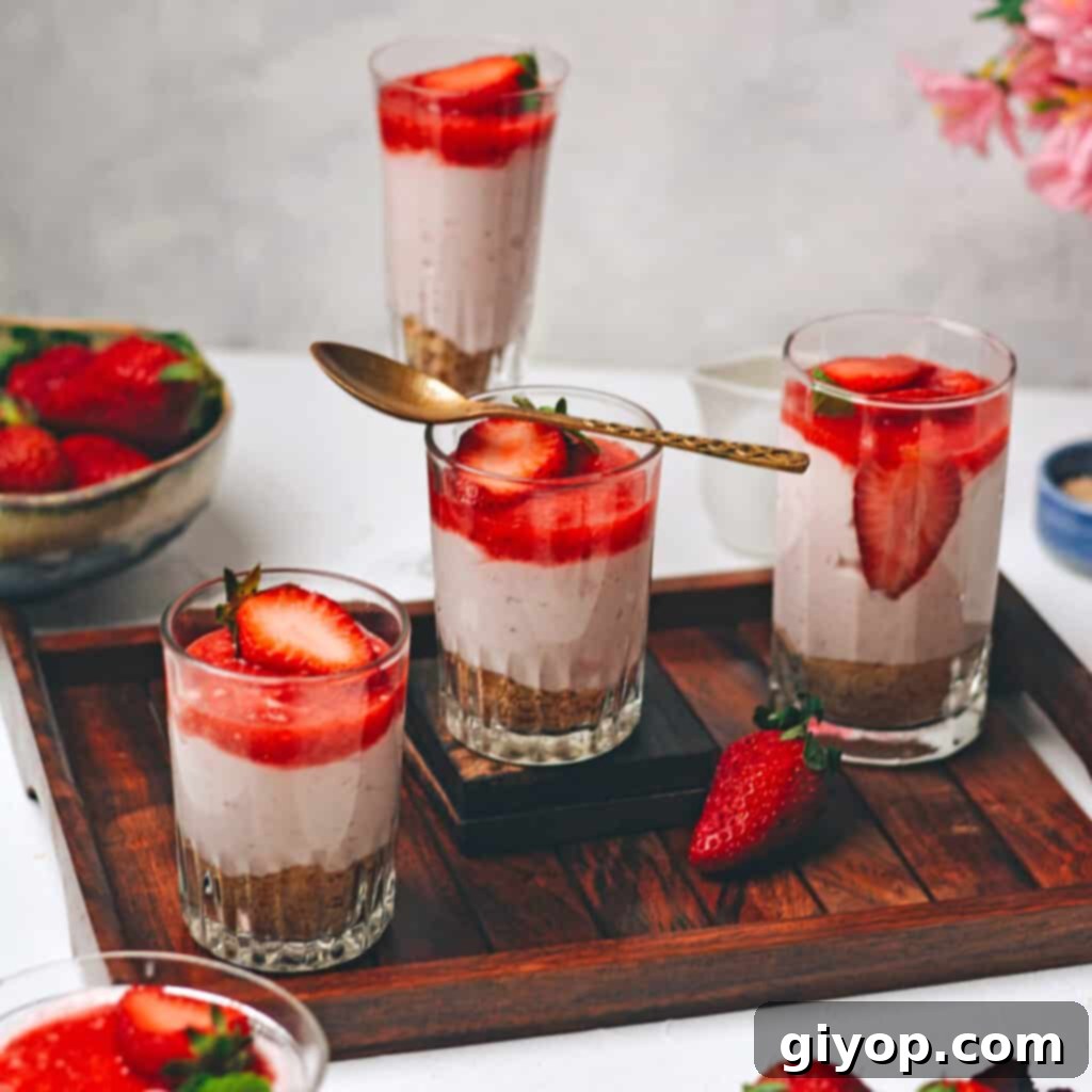 Meal Plan 7 A rustic wooden tray holds individual cups brimming with luscious strawberry cream cheese dessert, elegantly topped with freshly sliced strawberries, ready to be enjoyed.