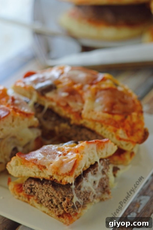 Two deliciously prepared pizza burgers on a plate, garnished with fresh basil leaves, ready to be enjoyed.