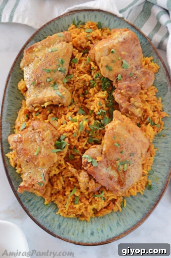 A large platter of aromatic Chicken Kabsa, a traditional Saudi dish, adorned with tender chicken and flavorful spiced rice.