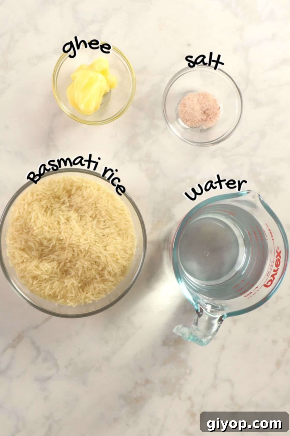 A close-up of Basmati rice grains, ghee, and salt, the simple ingredients needed for this recipe.