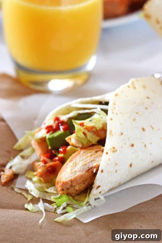 Custom Meal Plans 4 A plate of food featuring tender baked garlic chicken, wrapped in a warm tortilla, ready to be enjoyed.