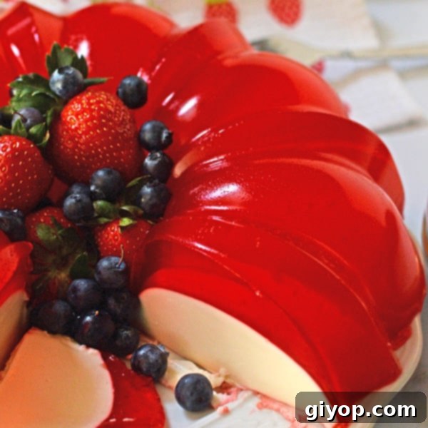 Custom Meal Plans 8 A close-up photo of a beautifully layered cream jello cake slice on a plate, showcasing its vibrant strawberry hues and creamy texture.