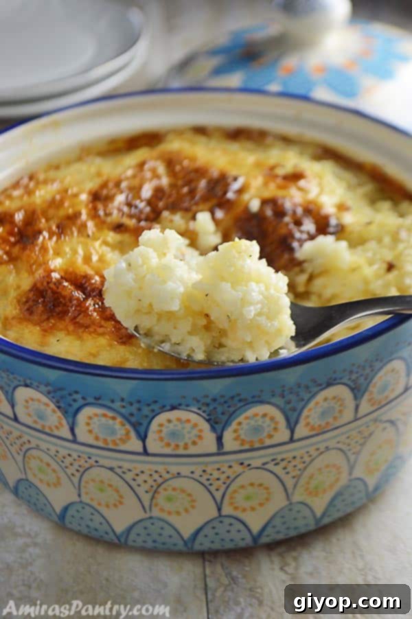 A close up of a bowl of food, with Rice pudding and spoon