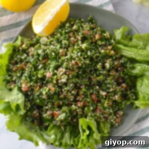Fresh Tabbouleh Salad 2 An overhead view of a plate of tabouli salad with lemon wedges on the side, ready to be served.