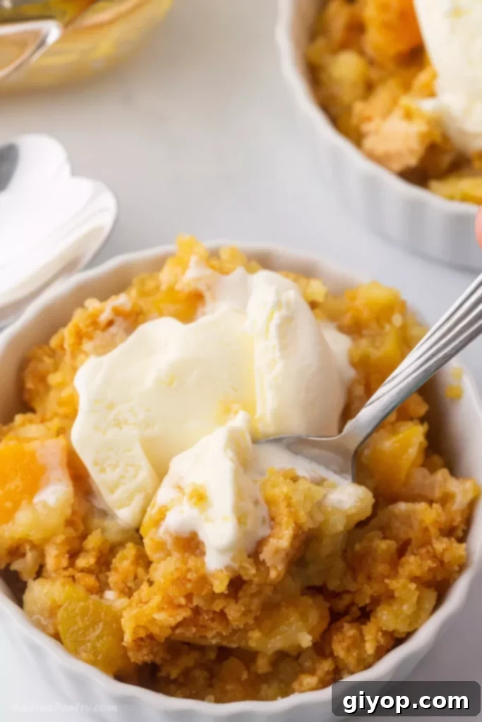 A warm, inviting bowl of peach cobbler, generously topped with a scoop of melting vanilla ice cream, promising a delightful dessert experience.