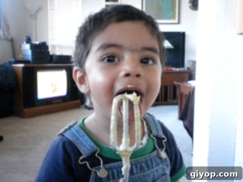 My son eating some food, with Marble cake dough. A child licking beaters after making marble cake.
