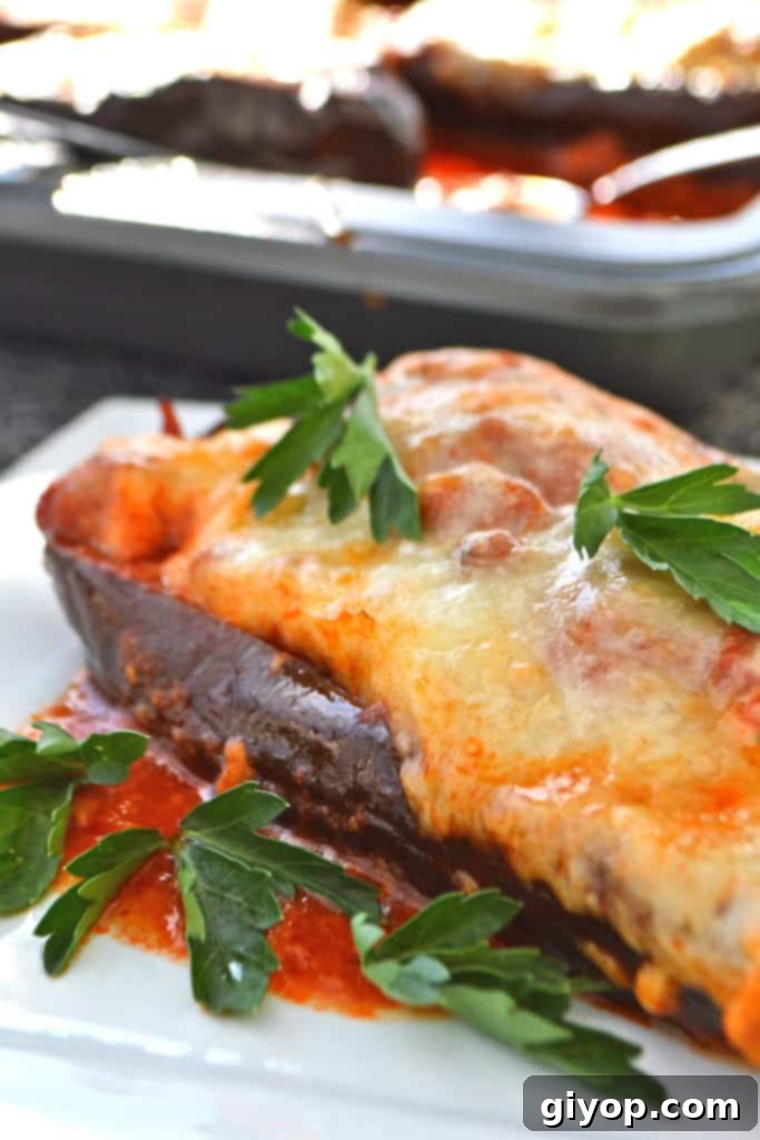 Your 28-Day Eating Guide 6 A close up of a plate of food, with Moussaka-style Eggplant Boats topped with cheese and sauce.