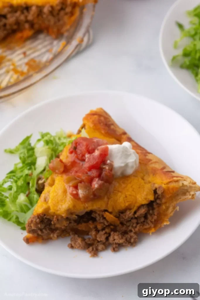 Effortless Meal Planning 3 A delicious slice of Taco Crescent Pie on a white plate, ready to be served.