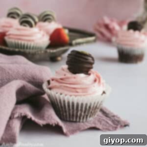 A strawberry chocolate cupcake on a pink towel, highlighting its appealing decoration.