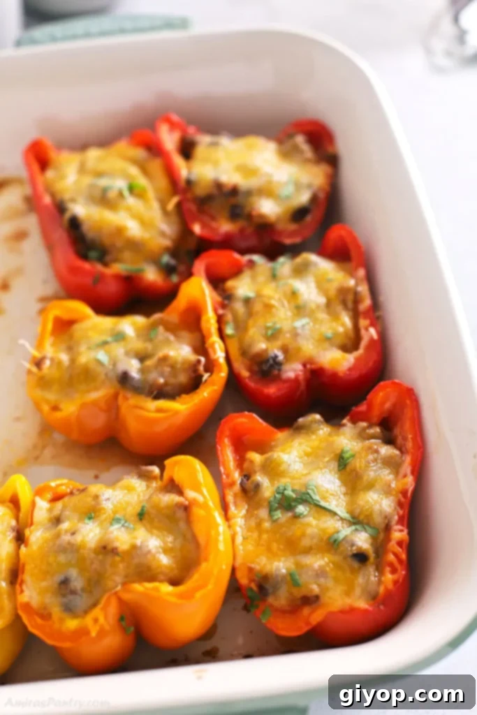 Hearty taco stuffed bell peppers baked in a white casserole dish, a perfect family-friendly dinner idea for Tuesday.