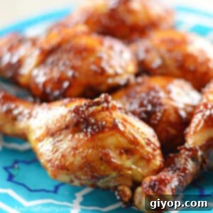 BBQ drumsticks on a blue plate placed on a wooden countertop