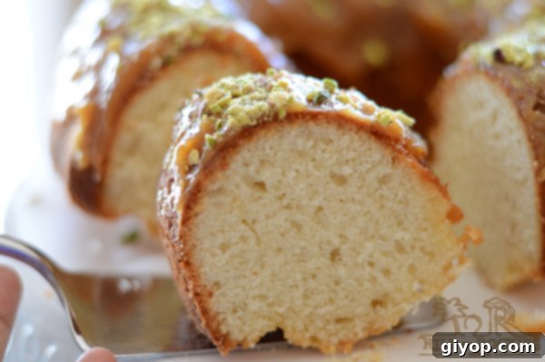 A close-up view of a baked yogurt cake drizzled with toffee glaze and pecans