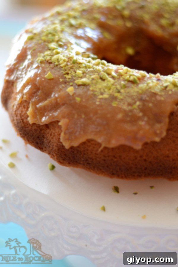 A serving of homemade yogurt cake on a plate, adorned with creamy frosting and crunchy nuts