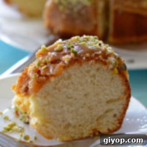 A close-up of a single portion of yogurt cake, perfectly glazed and garnished with nuts